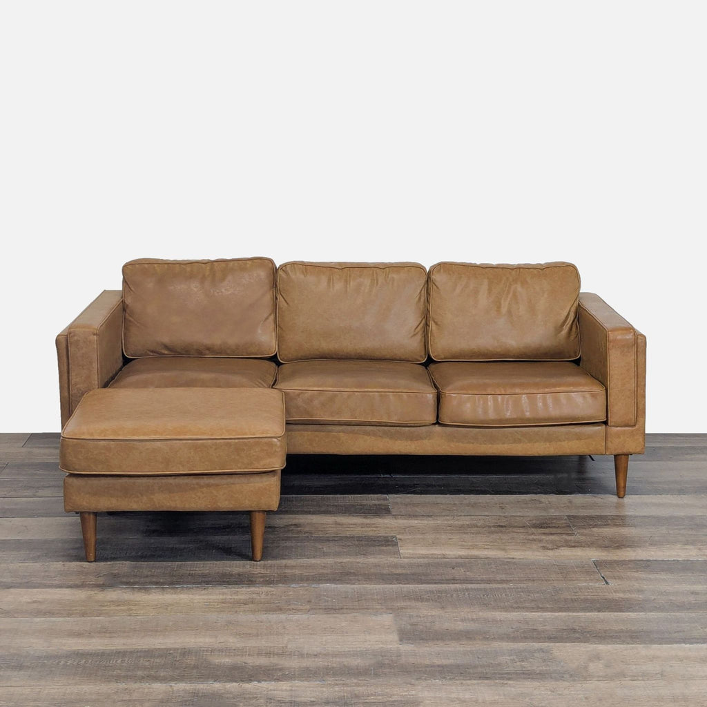 1. Albany Park 3-seat sofa in vegan leather with tapered walnut legs, shown with ottoman front view.