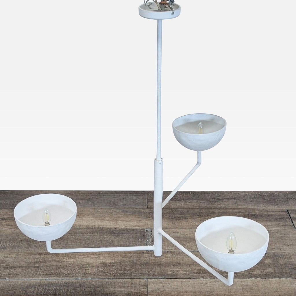 2. Close-up of three-tiered white pendant light by CB2, showing bulb placements in rounded bowl shades.  