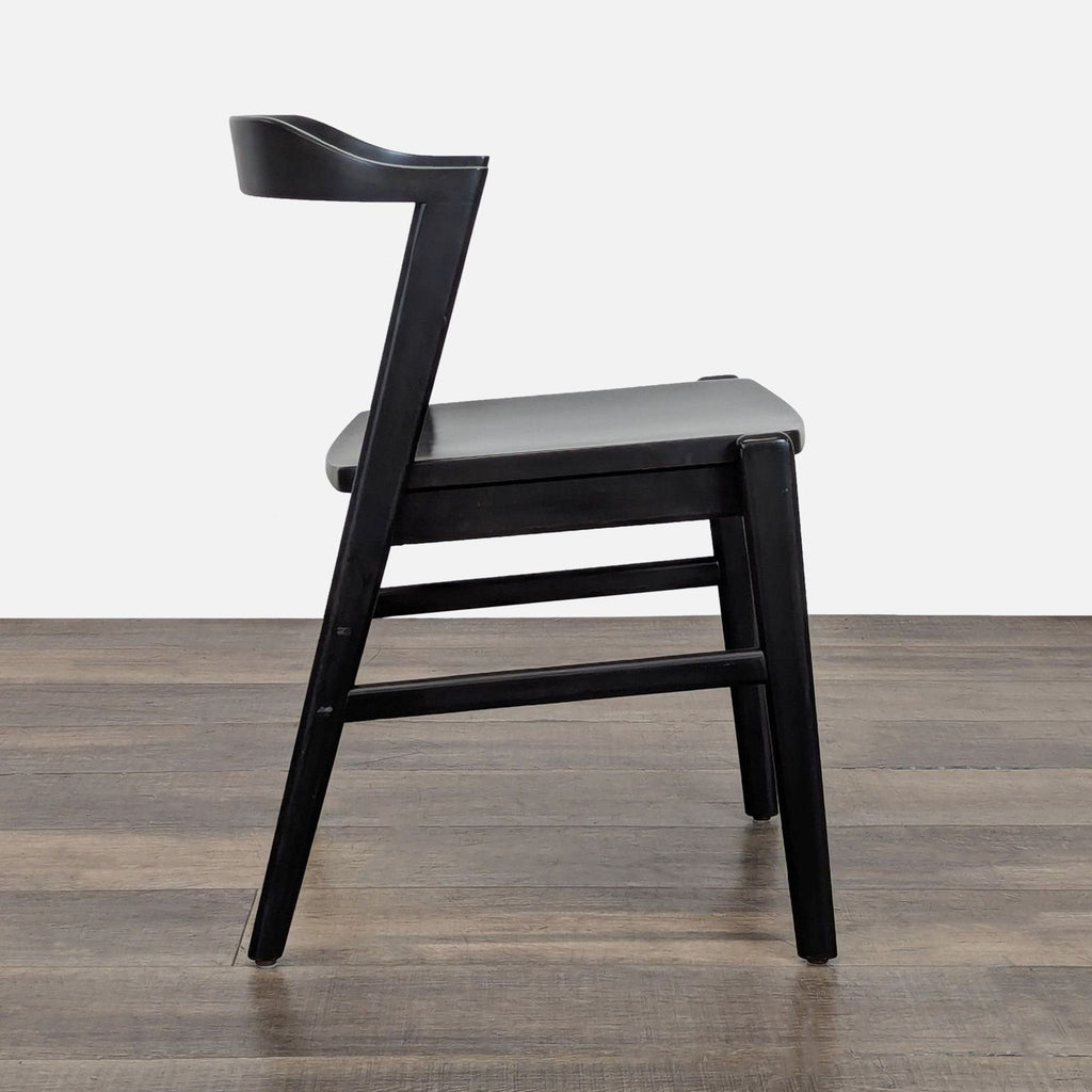 Side view of a black Reperch dining chair, showcasing its contoured backrest and sturdy frame.