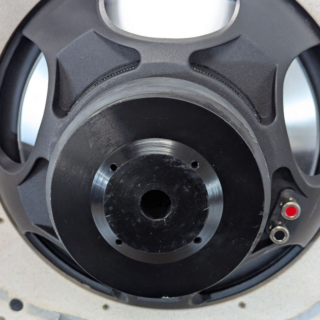 Close-up of the rear side of a CAT 6.5" aluminum cone driver, highlighting the magnet and speaker terminals.