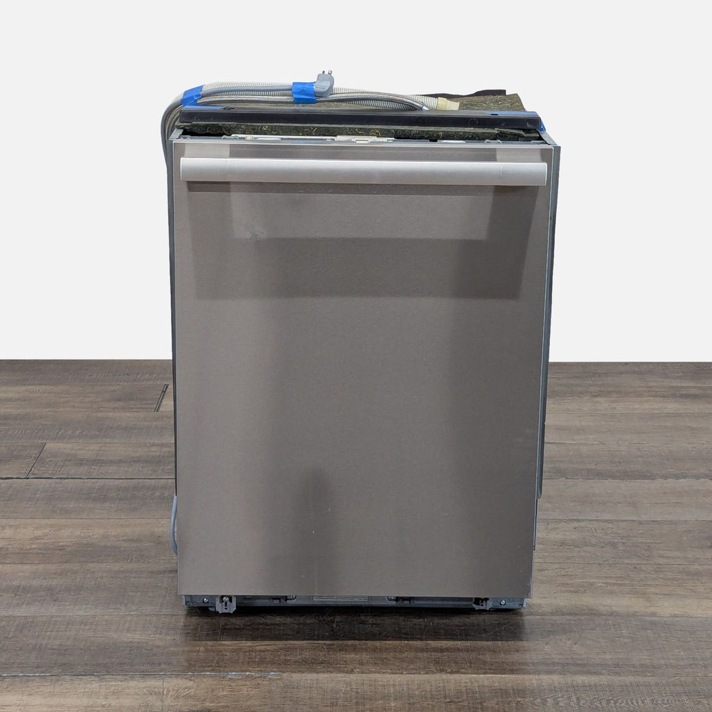 1. Front view of a Miele G6875SCVI fully integrated, panel-ready dishwasher set on a wooden floor.