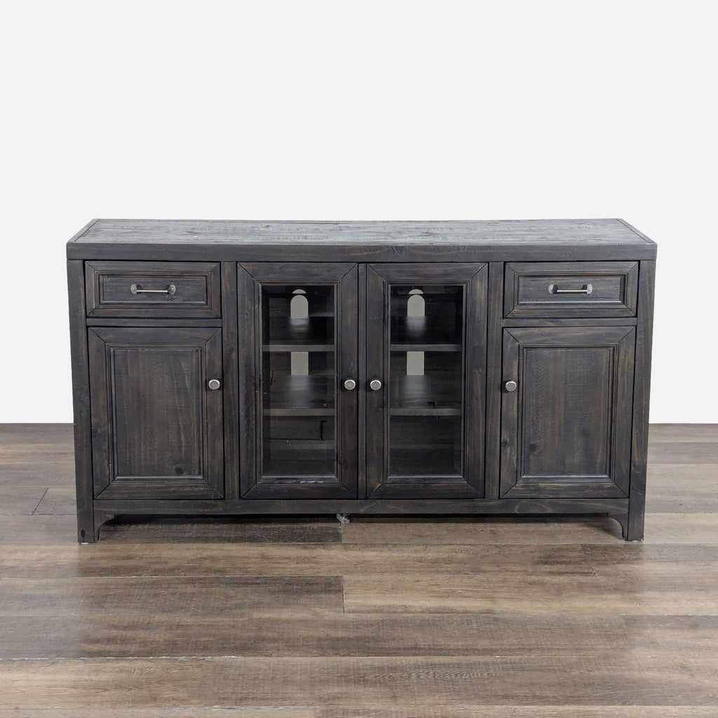 1. Dark wood Living Spaces entertainment center with glass-paneled doors, two drawers, and cabinet storage.