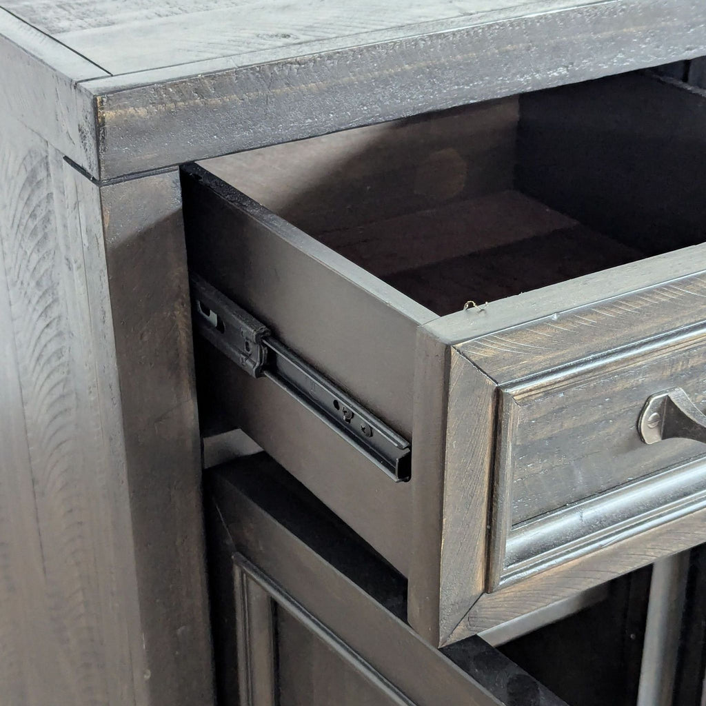 3. Close-up of a Living Spaces entertainment center drawer, highlighting the wood finish and sturdy drawer slide.