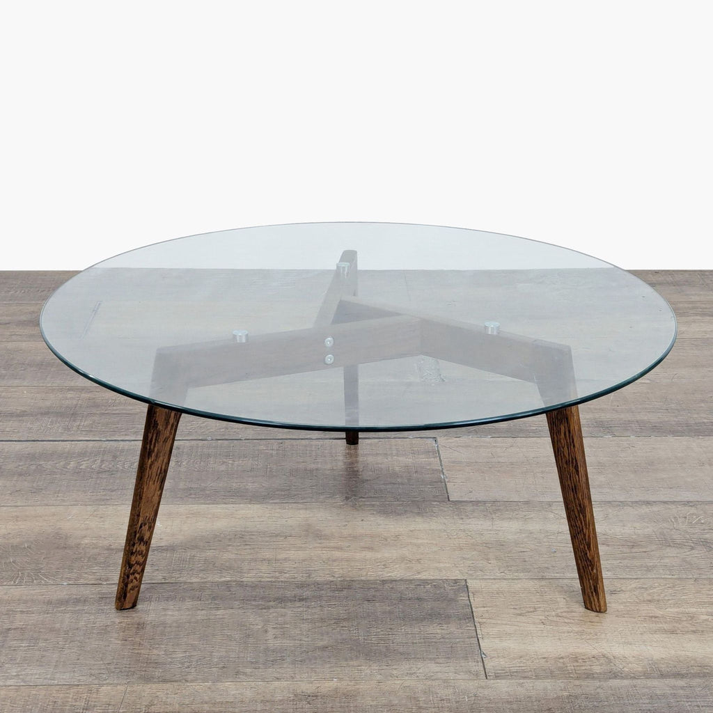 2. Modern Article coffee table featuring a transparent round glass top and dark wooden base.