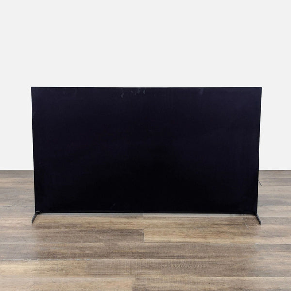 1. Rear view of a Sony XR-65A95L 65-inch QD-OLED TV with a slim design and metal stand on wooden floor.