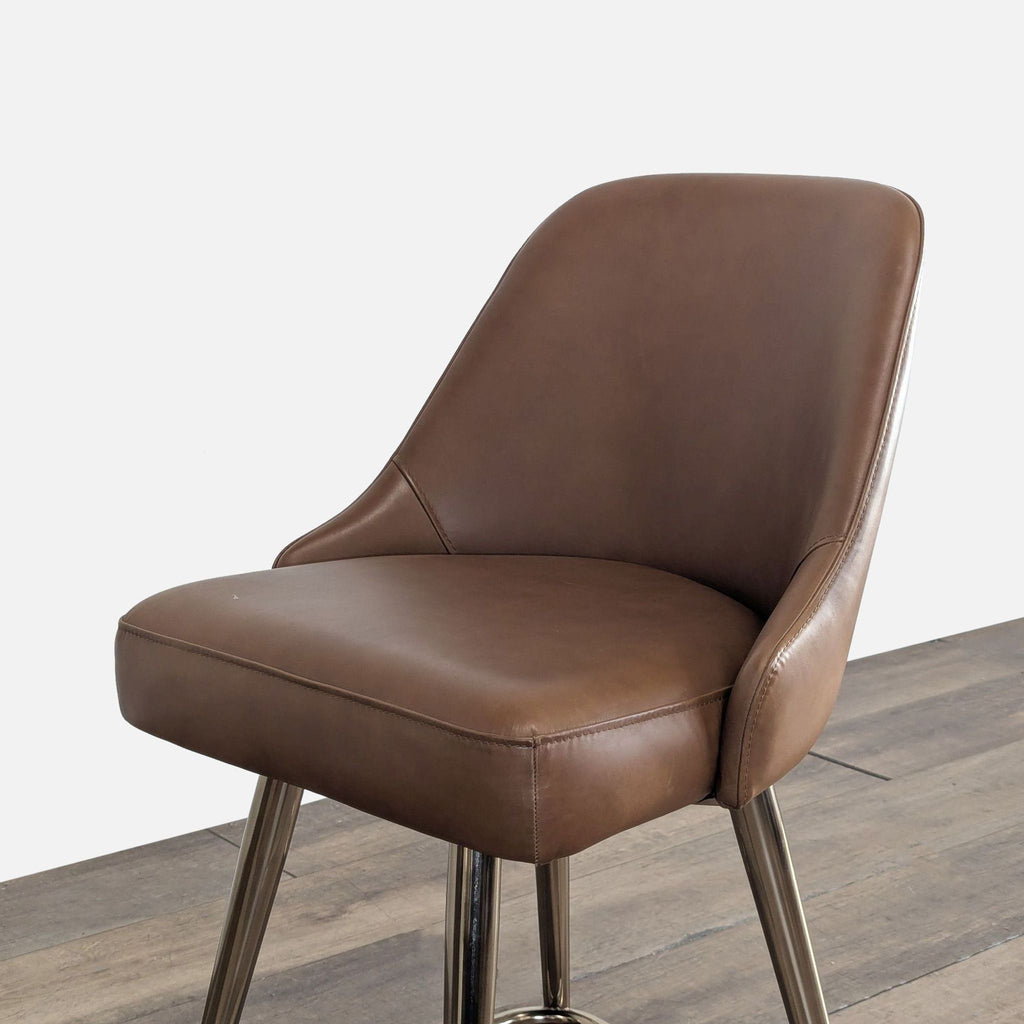 2. Angled view of a West Elm brown leather stool, showing sleek stitching and supportive cushioned seat.