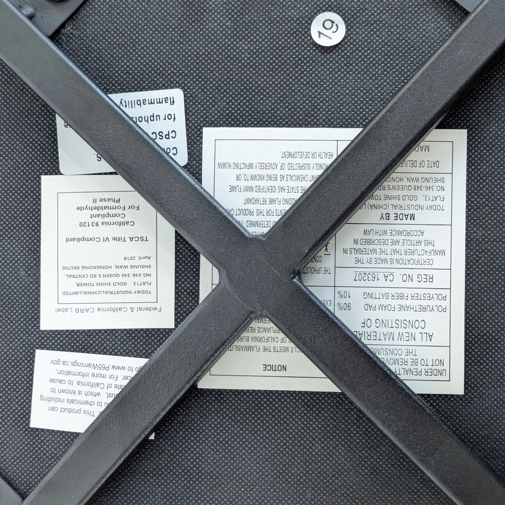 Underside of a Reperch dining chair showing product information labels and metal support frame.