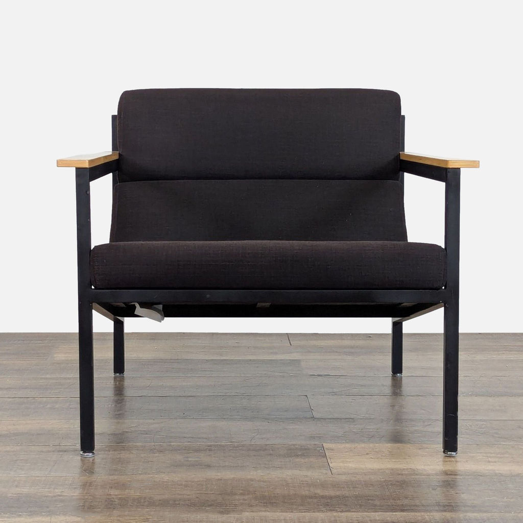 Front view of a Gus* lounge chair with a powder-coated steel frame, wood armrests, and faceted upholstery.  