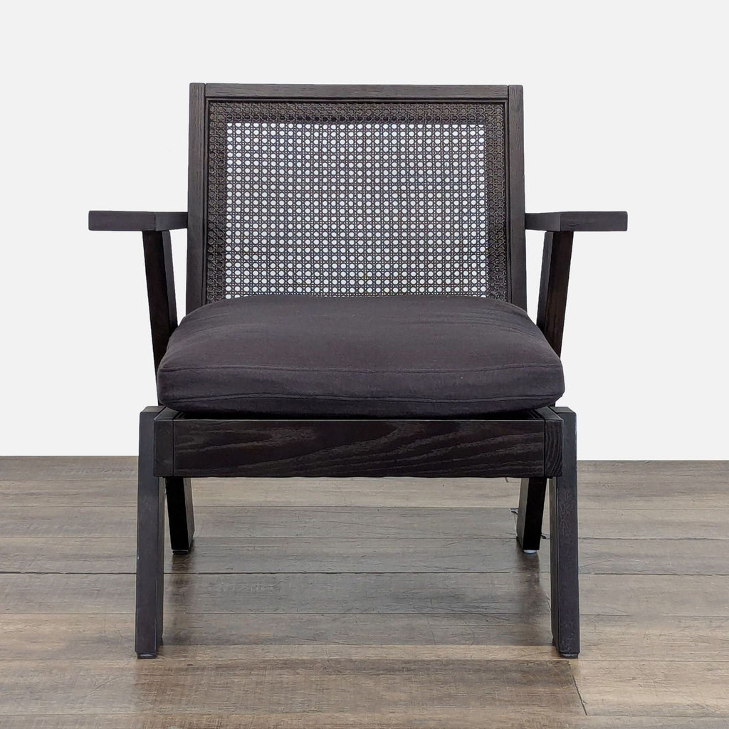 Front view of Crate & Barrel Jeannie Cane Accent Chair with solid oak frame, cane back, and charcoal cushion.