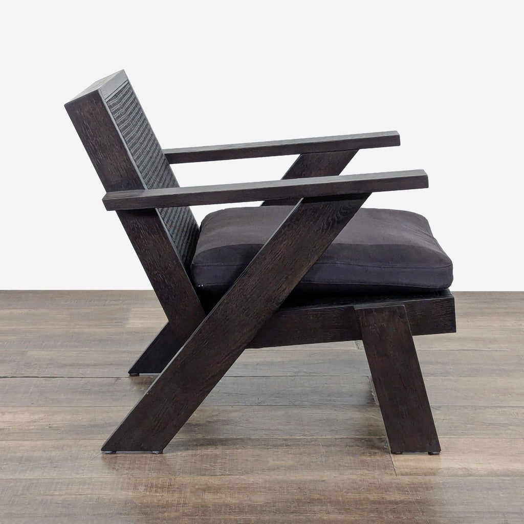 Side view of Crate & Barrel lounge chair showing angled oak frame, armrests, and charcoal cushioned seat.
