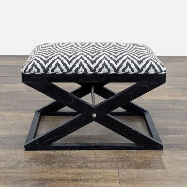 1. Brownstone Furniture ottoman with black and cream chevron padded seat and X-shaped wooden frame, side view.