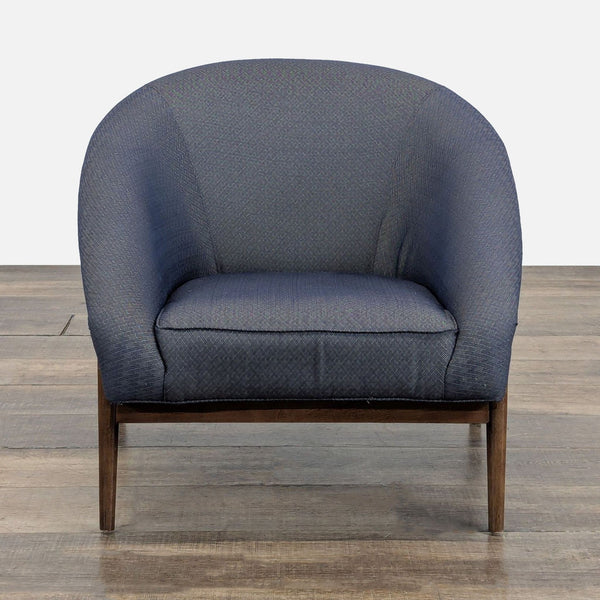 Front view of a dark blue Reperch lounge armchair with textured fabric and dark wooden legs.  