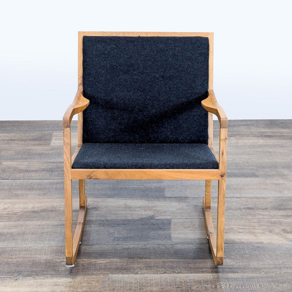 Front view of a lounge rocker chair with a walnut wood frame and charcoal black tweed upholstery, by H.D. Buttercup.