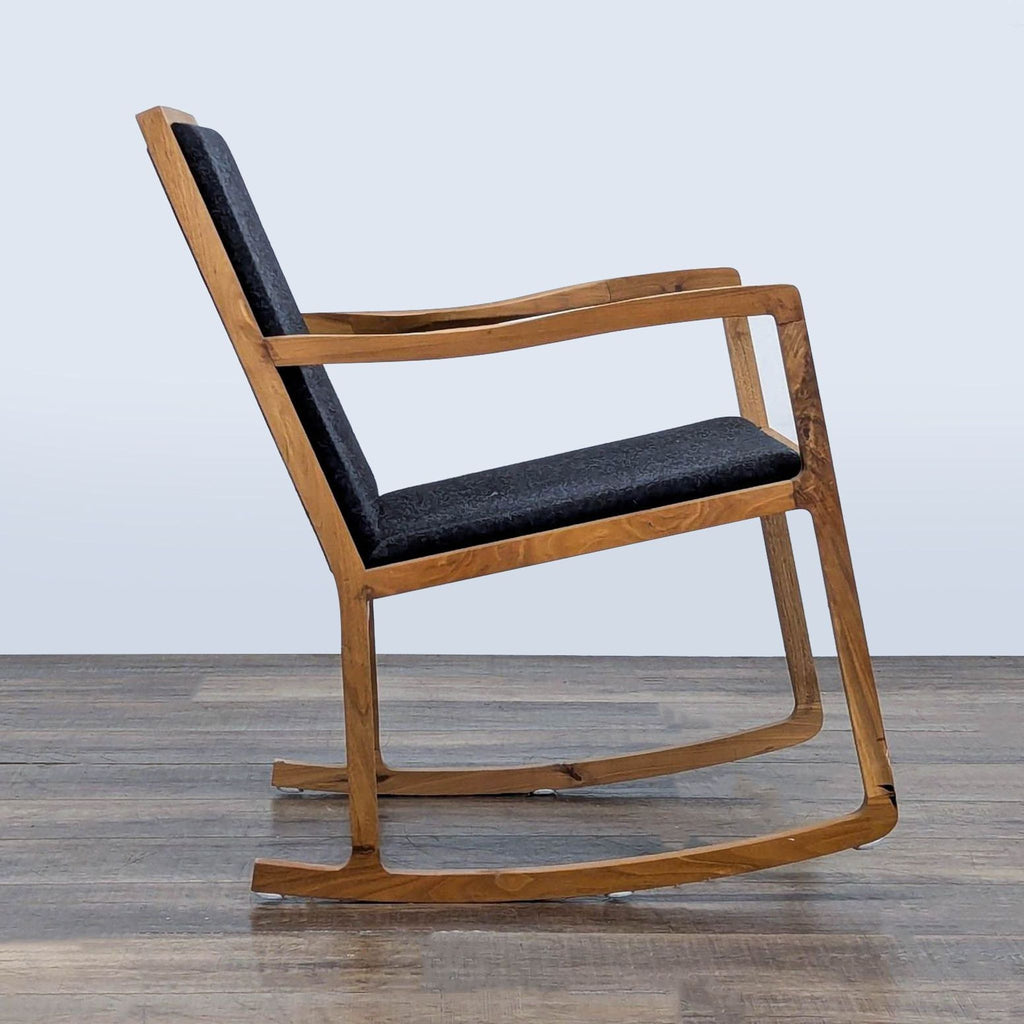 Side profile of a modern lounge rocker, showcasing walnut wood frame and black tweed fabric, H.D. Buttercup brand.