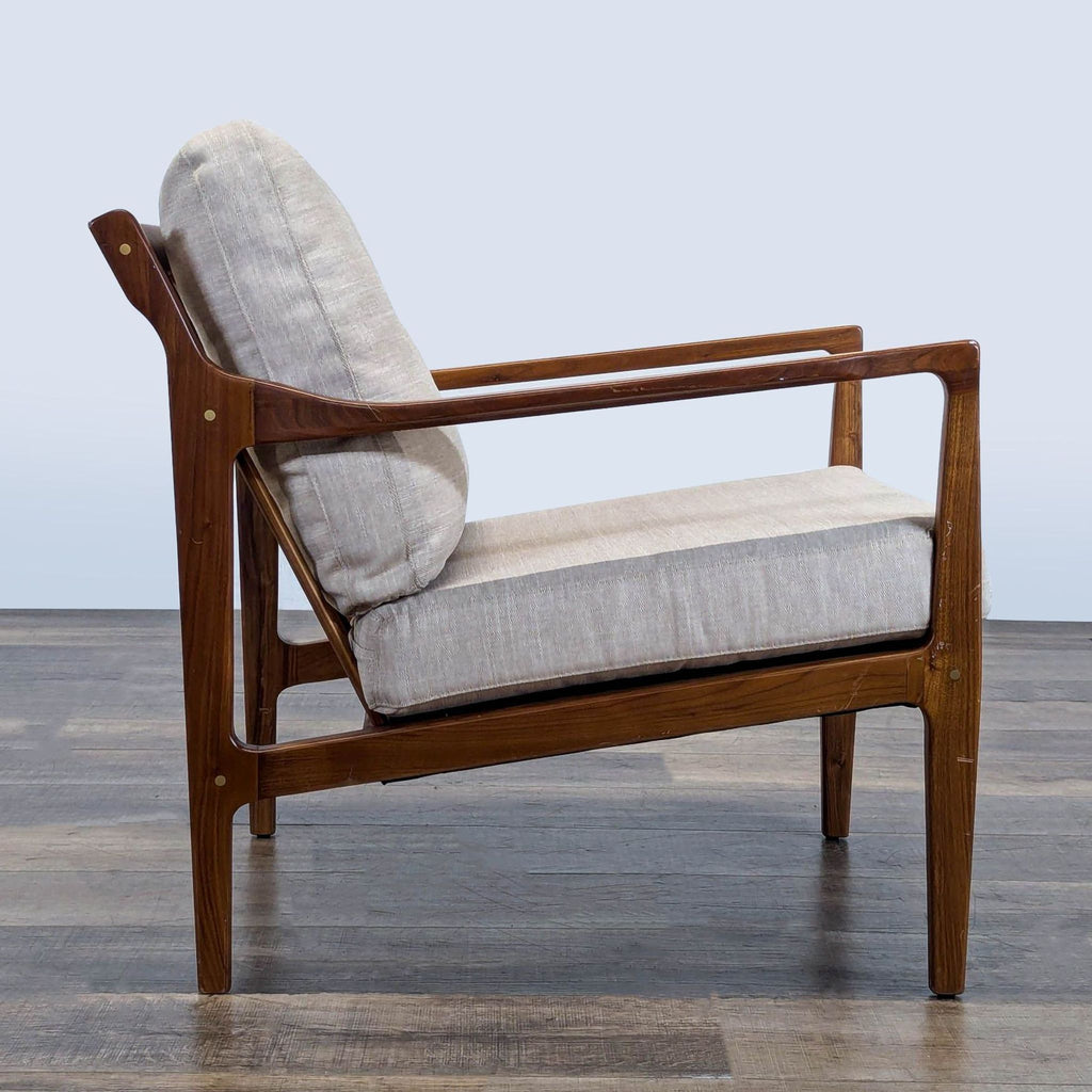 2. Side profile of a Reperch lounge chair showing tapered legs, slatted back, and cushioned seat.