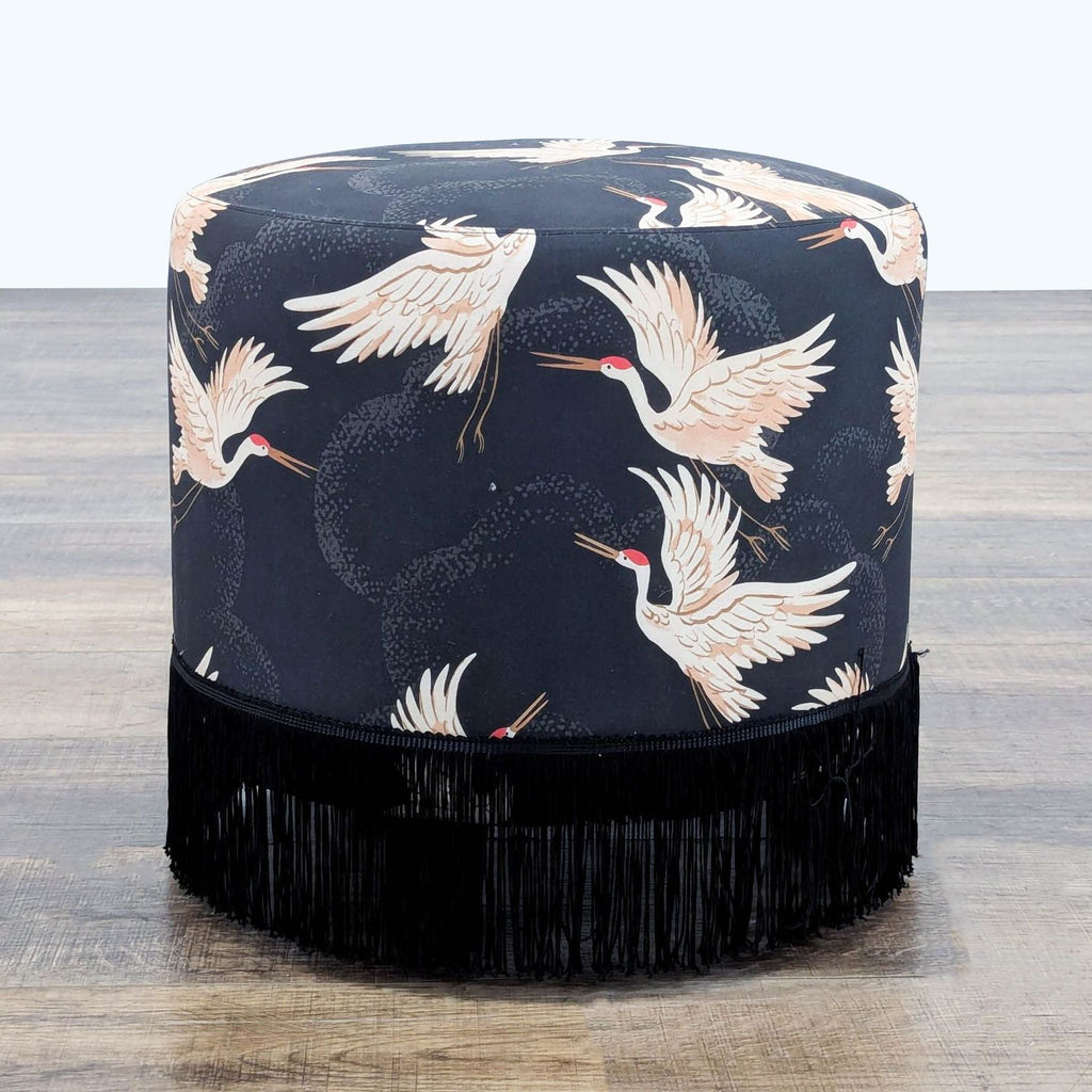 2. Skyline Furniture stool featuring cream flying cranes on a dark background with decorative black fringe trim.