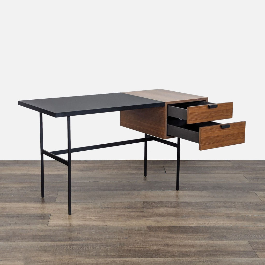 2. Side view of a Ligne Roset desk showing soft-touch black surface and open natural walnut veneer drawers.