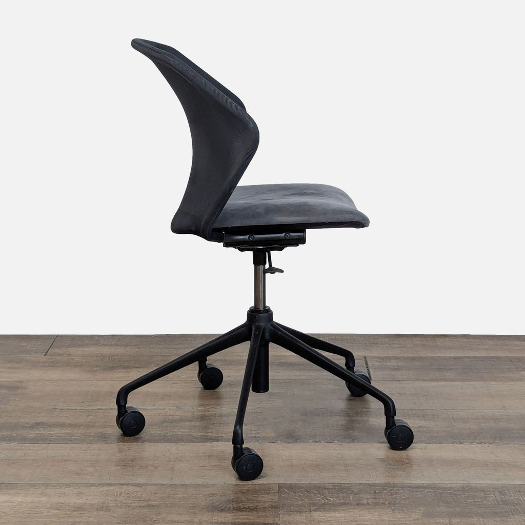 2. Side view of a gray mesh ergonomic chair with padded seat, curved backrest, and caster base by Ligne Roset.