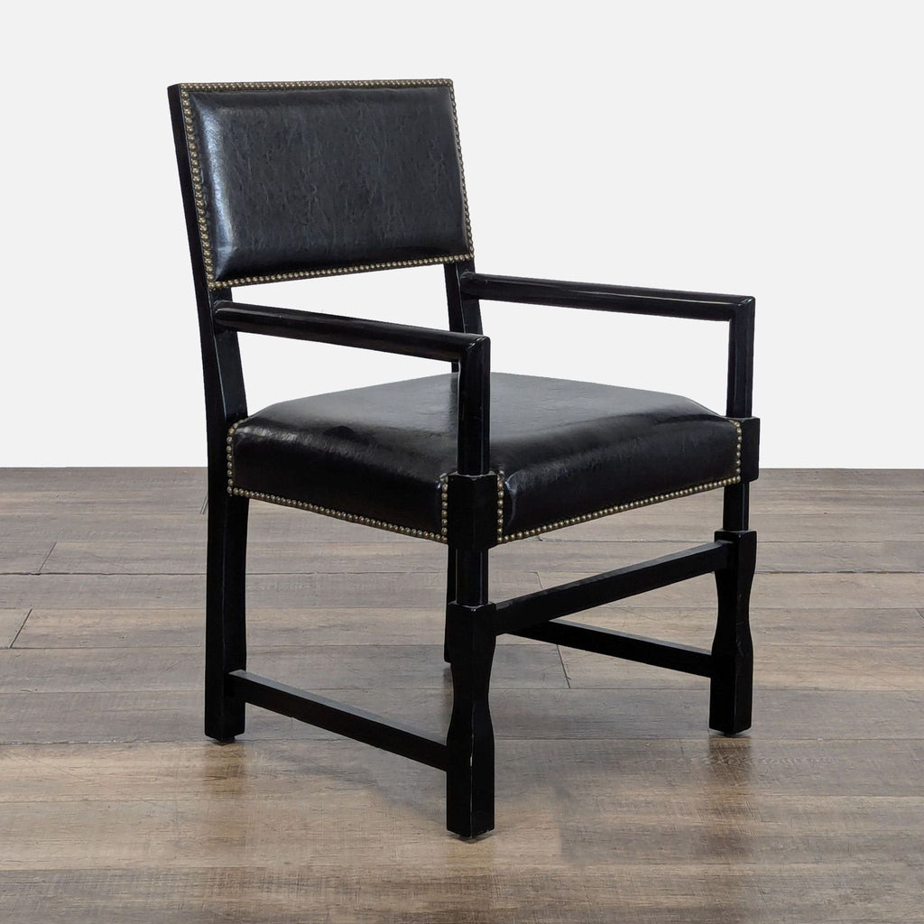 2. Black dining chair by Reperch featuring wood frame, armrests, and nailhead trim, angled side view.