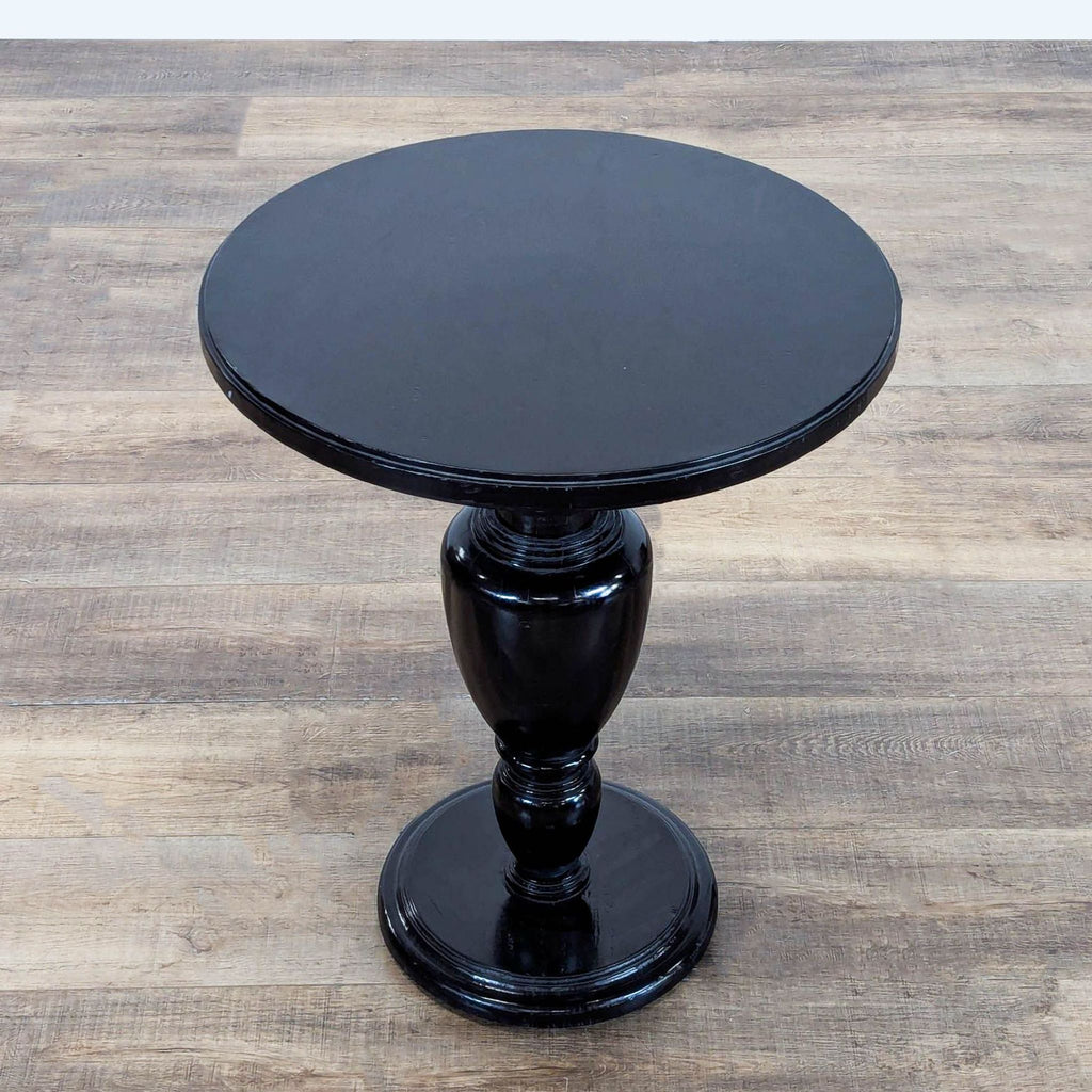 2. Overhead view of Reperch round black side table with a glossy pedestal base.