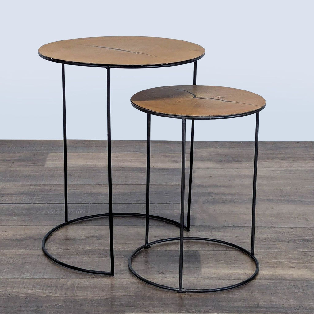 2. Two Reperch round side tables with slender black metal legs and wood tops, placed side by side on wood flooring.