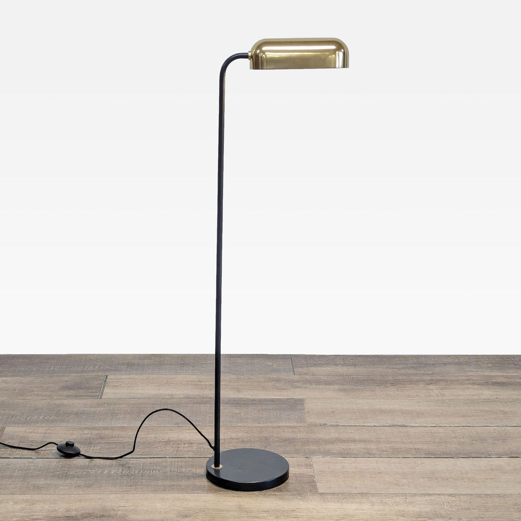 1. Full view of a Reperch floor lamp with a blackened bronze body and a brass shade, shown on wood flooring.