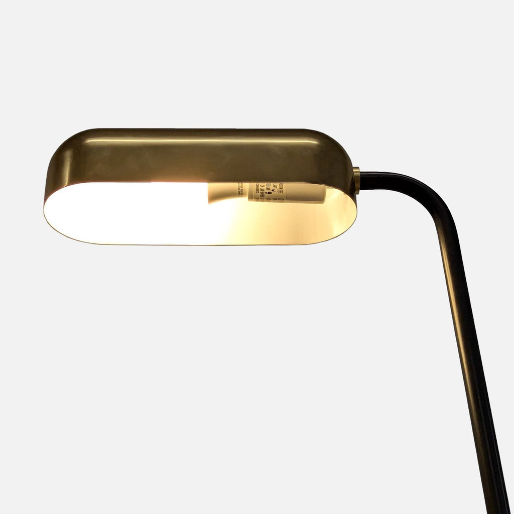 2. Close-up of the Reperch floor lamp's brass shade, highlighting its modern, metallic finish and bulb inside.
