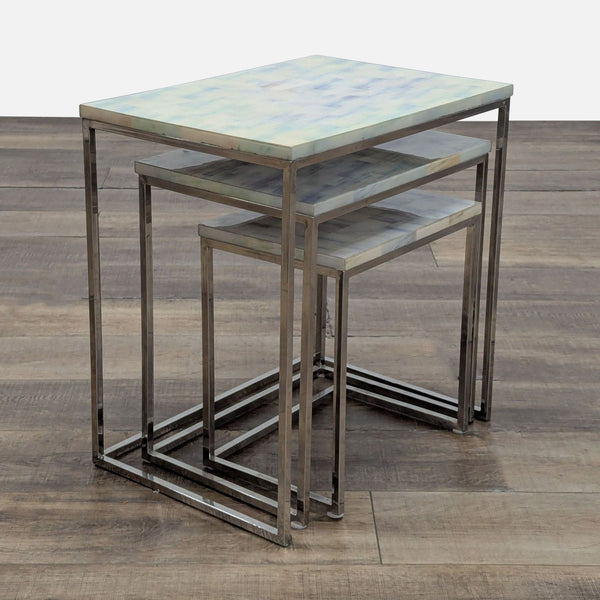 1. Set of three HD Buttercup nesting end tables with chrome frames and light, patterned tops on wood floor.