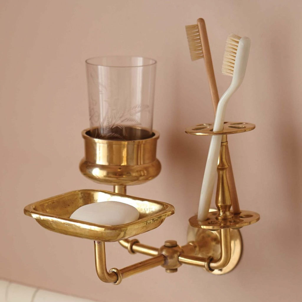 1. Brass wall-mounted bathroom organizer by Sir/Madam, holding toothbrushes, a soap bar, and a glass cup.
