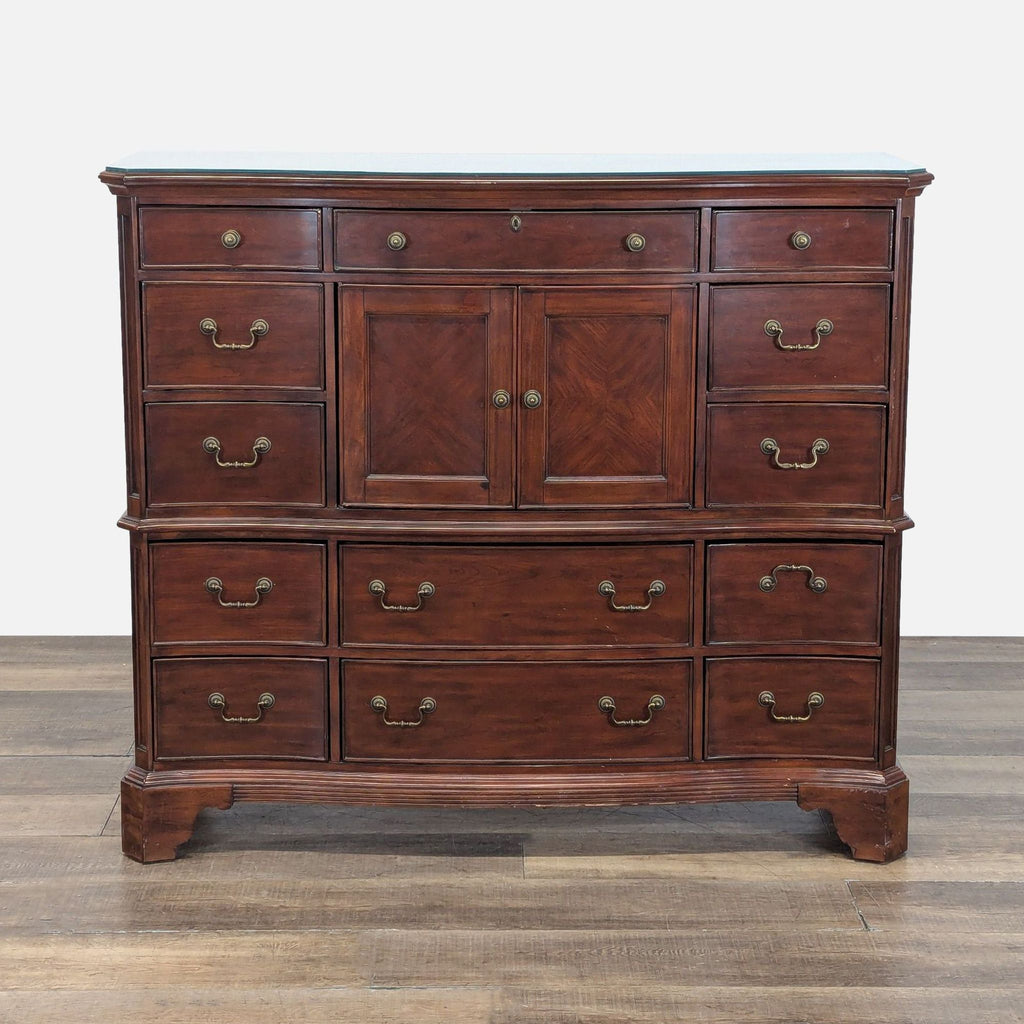 Reperch dresser with dark wood finish, 13 curved drawers, central cabinet, and brass hardware, closed view.