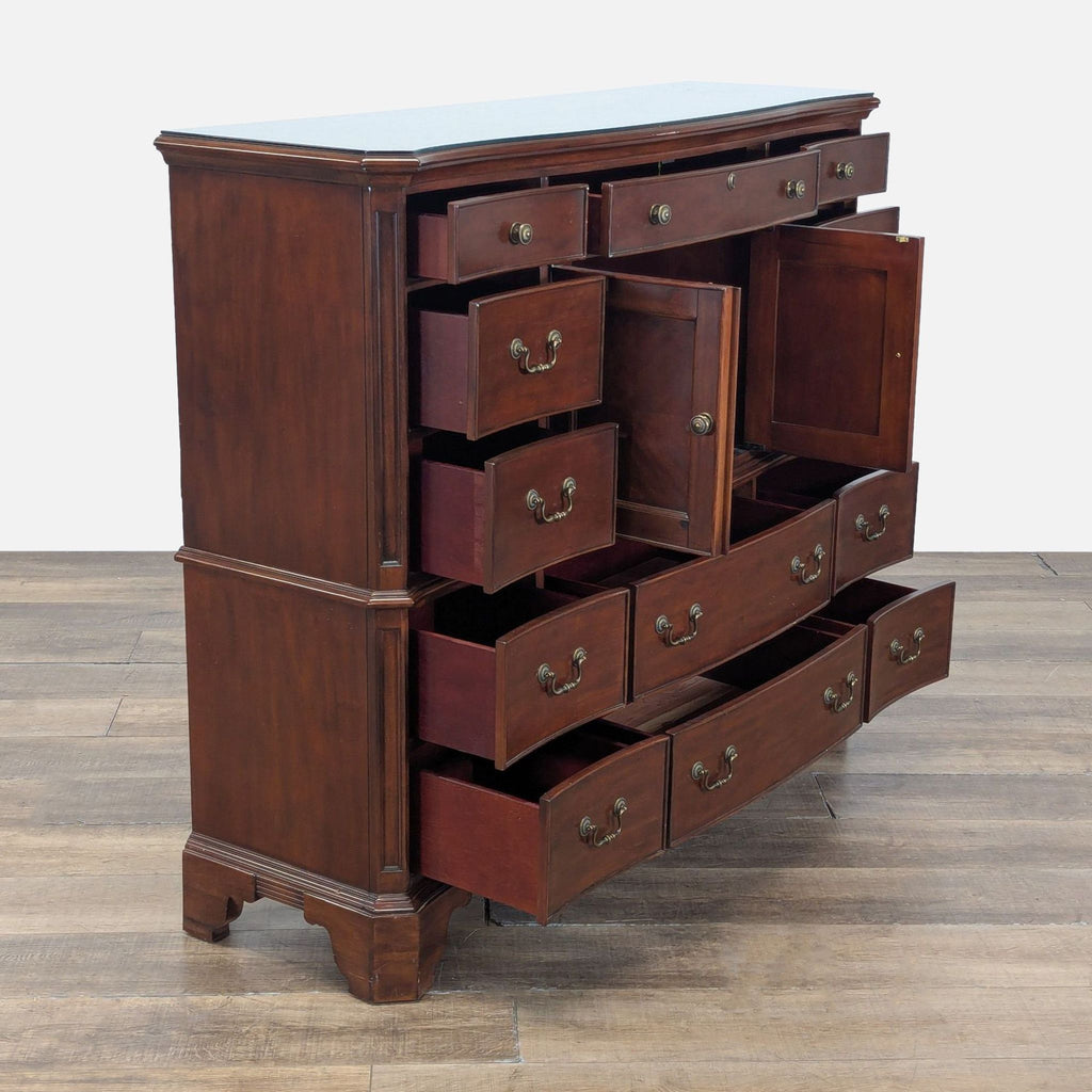 Angled view of Reperch dark wood dresser, highlighting open curved drawers, central cabinet, and brass handles.