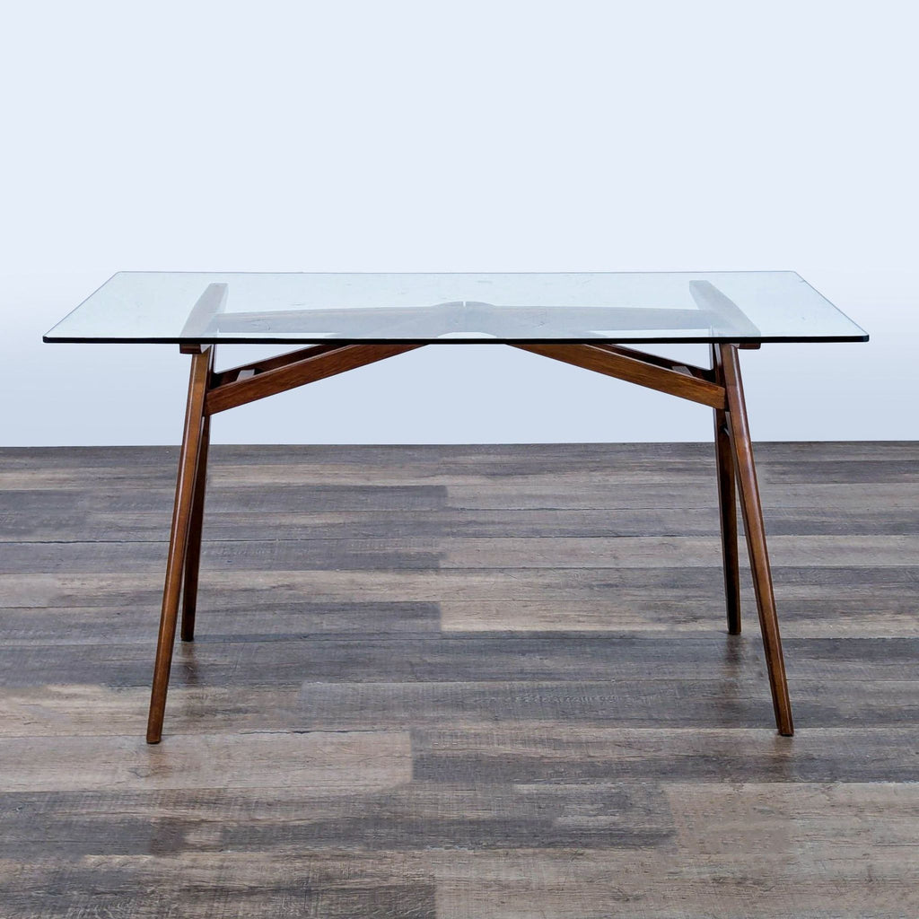 1. West Elm desk with a solid wood A-frame base and glass top, shown from the front on a wood floor.