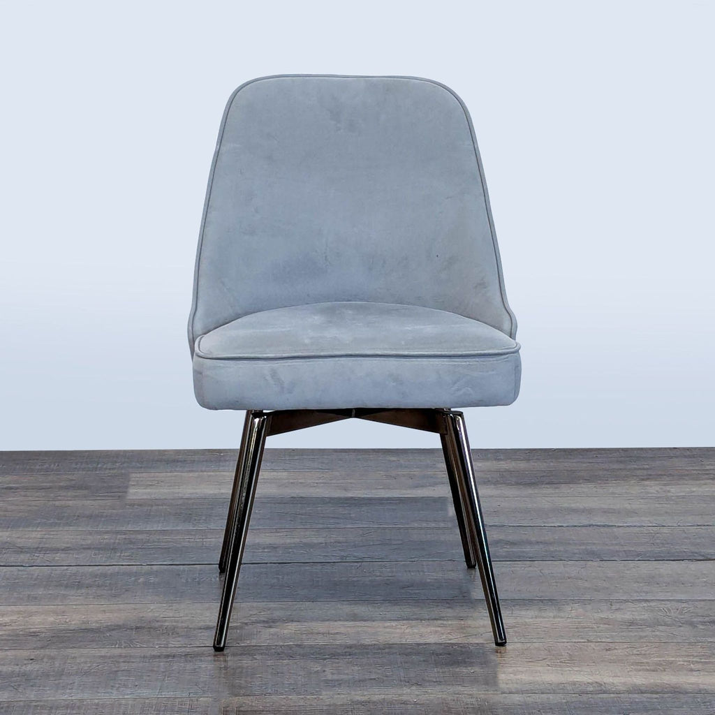 1. Front view of a West Elm chair with a wide swivel seat, sloping back, and metal base.