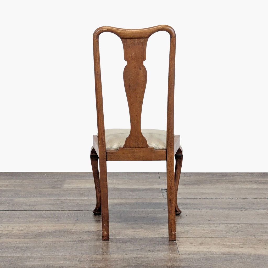 Single Reperch dining chair viewed from the back, showing curved wooden frame and light upholstered seat.  