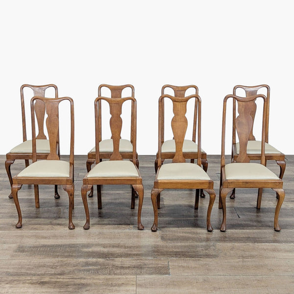 Set of six Reperch dining chairs with curved wooden frames and light upholstered seats, arranged on wood floor.  