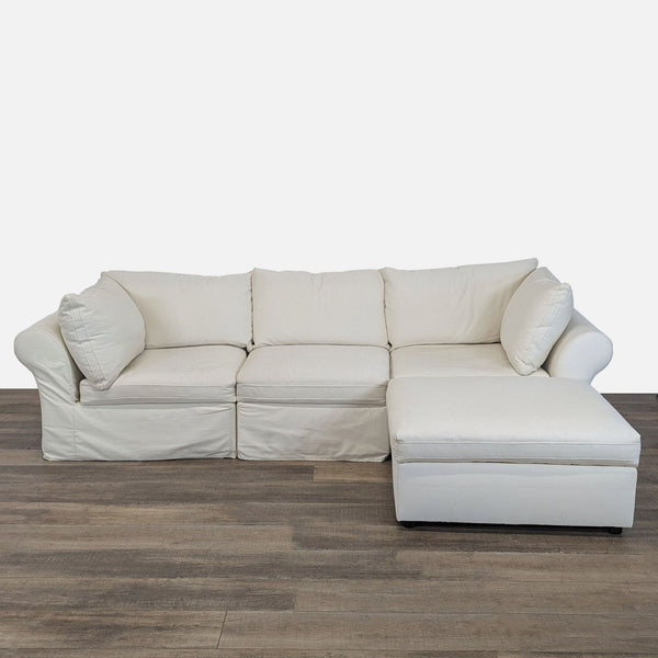 Front view of Pottery Barn Roll Arm Slipcovered 4-piece sectional with chaise in cream twill fabric.