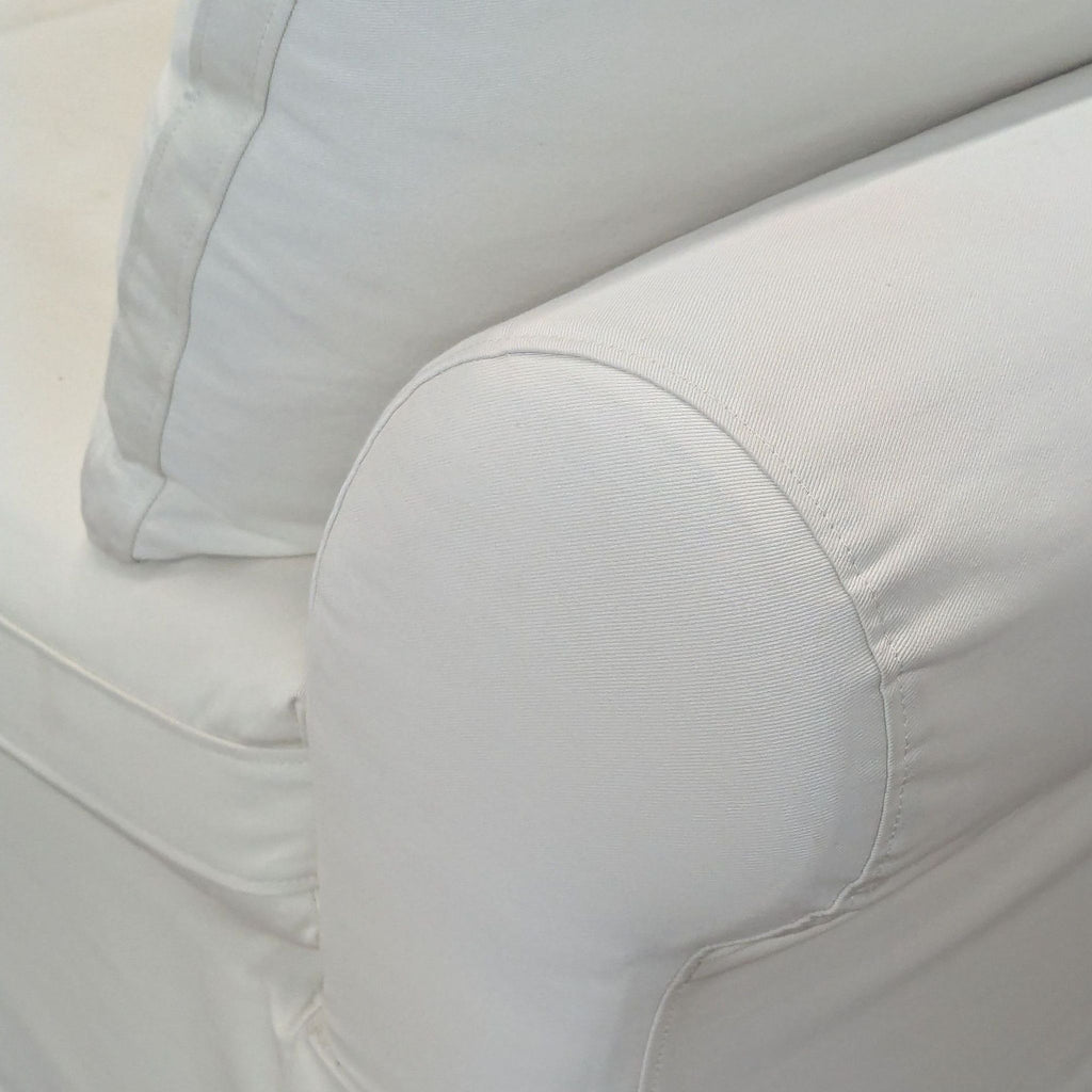 Close-up of the cream twill fabric and rolled arm detail on the Pottery Barn sectional sofa.