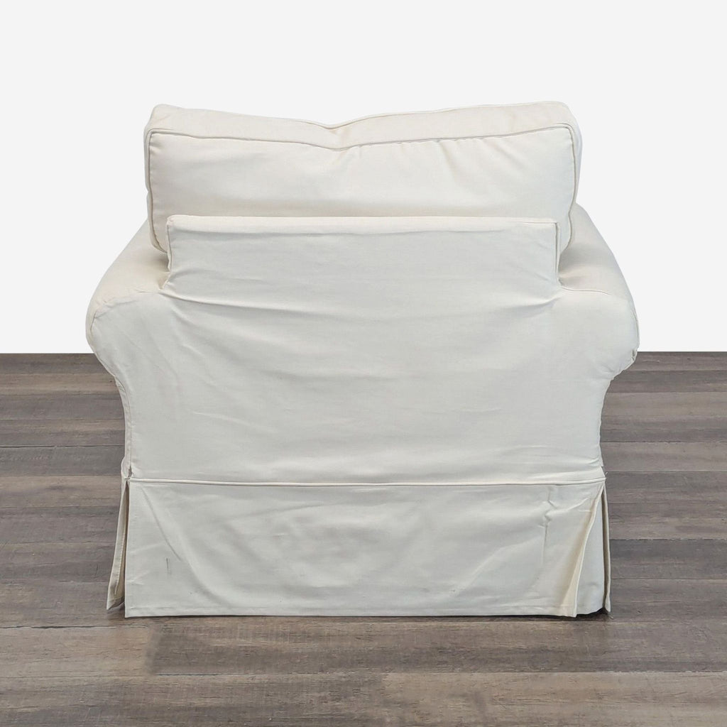 Back view of a Pottery Barn lounge chair with cream twill slipcover and plush seat cushions, lounge category.