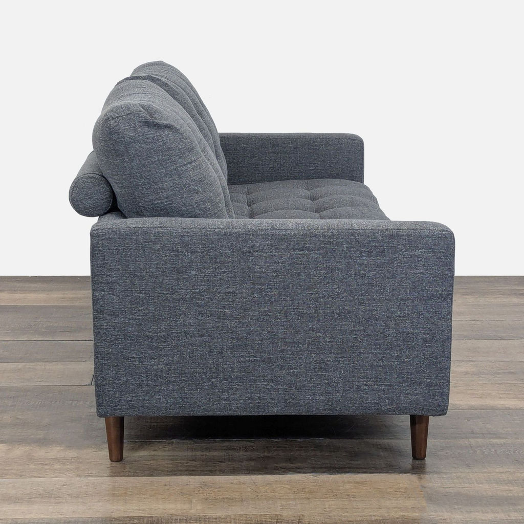 Side view of the Reperch Loveseat, showing armrest, tufted cushion, and tapered wood legs.  