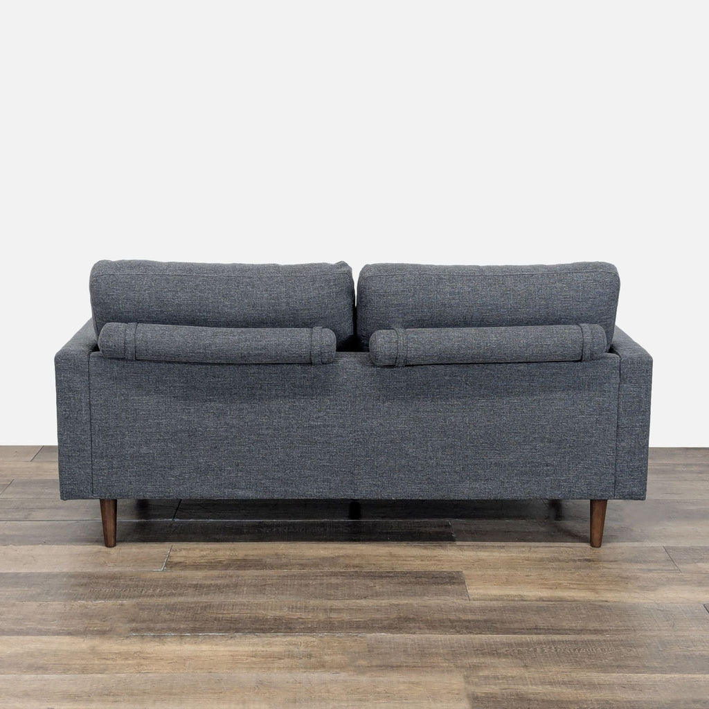 Back view of the Reperch Loveseat featuring cylindrical cushions and tapered wood feet.