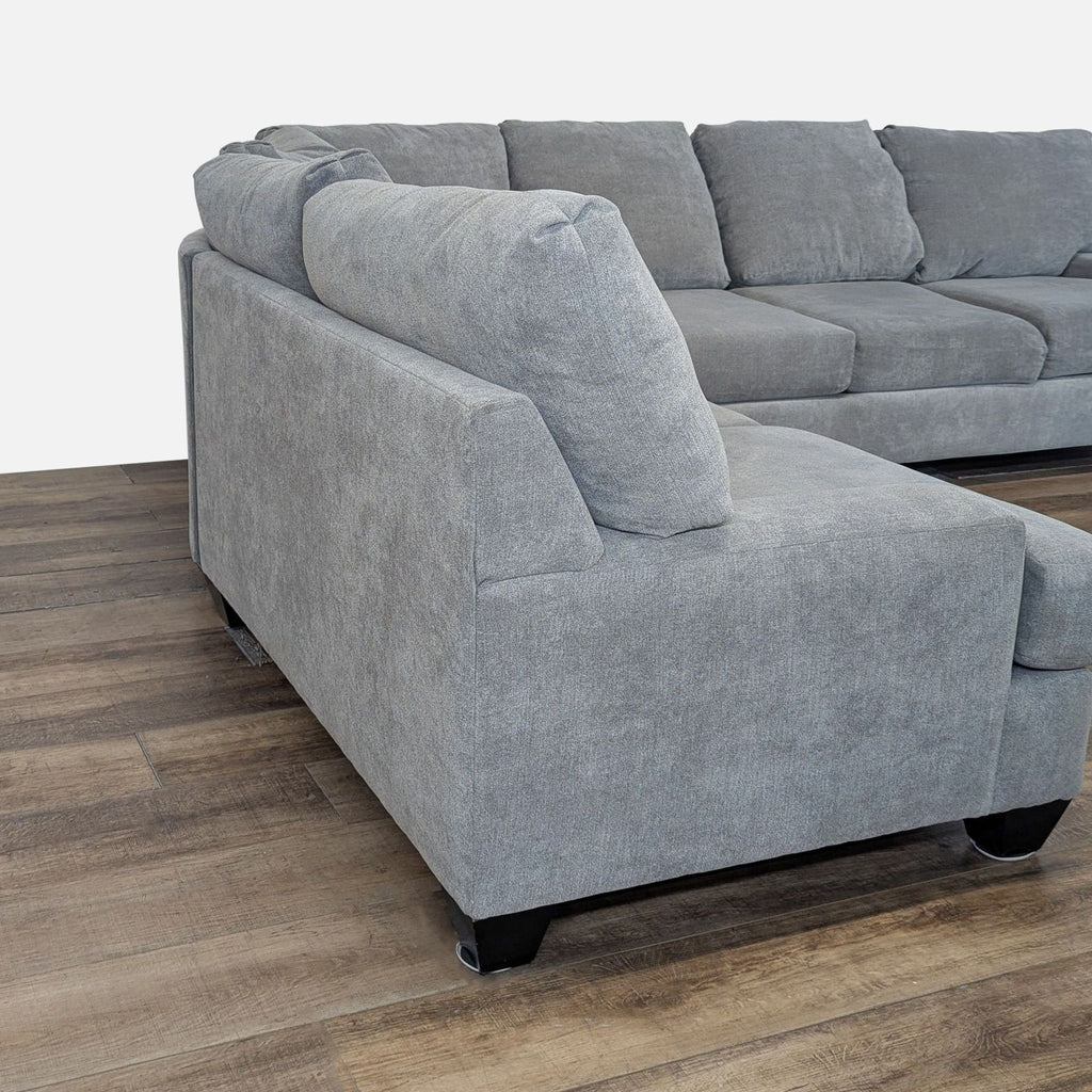 3. Close-up of the Living Spaces light gray sectional’s soft cushions, modern lines, and left-side chaise lounge.
