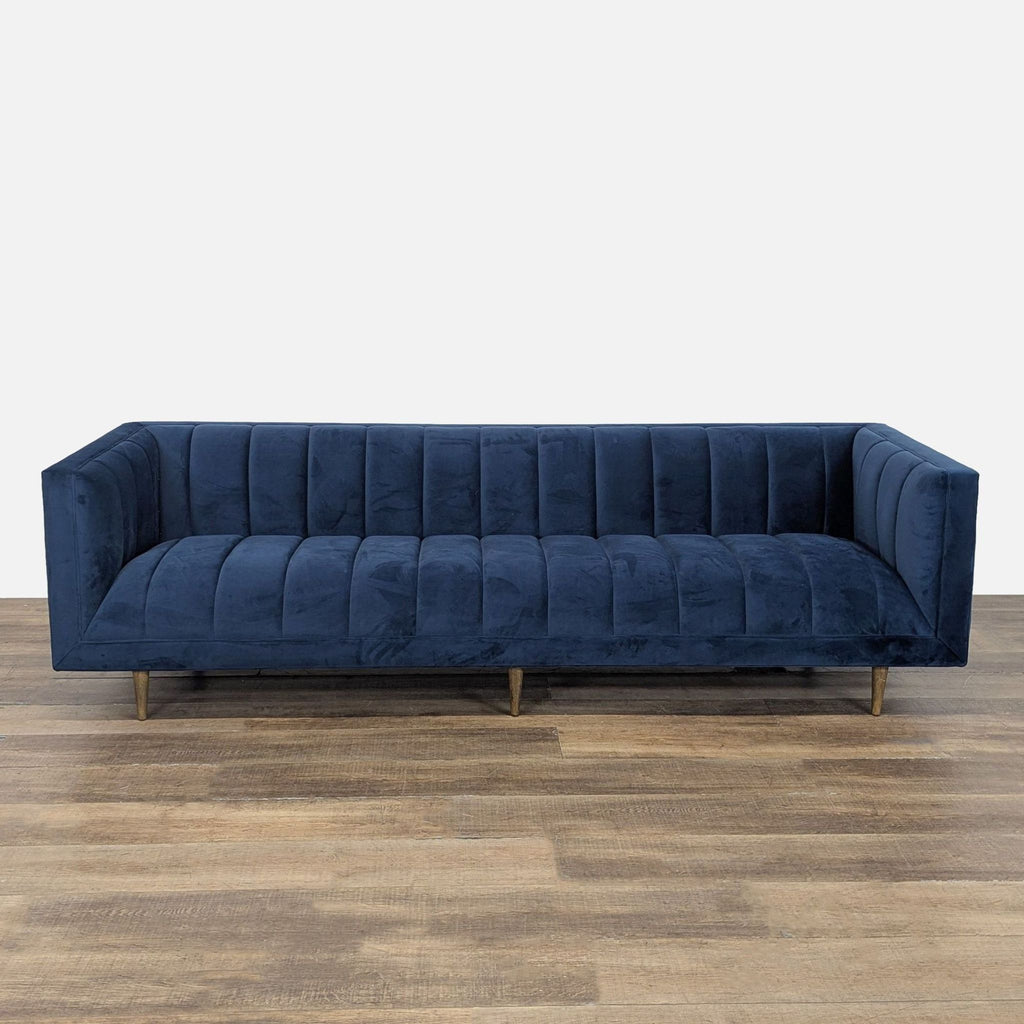 1. Four Hands 3-seat sofa in navy, featuring plush channel tufting, a tuxedo silhouette, and tapered wood legs.