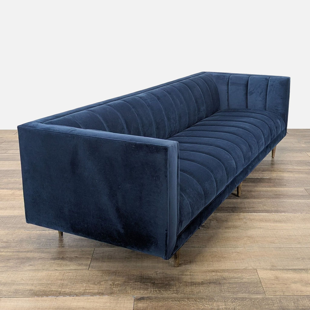 3. Angled view of Four Hands 3-seat sofa showing its navy upholstery, tuxedo silhouette, and wood tapered legs.