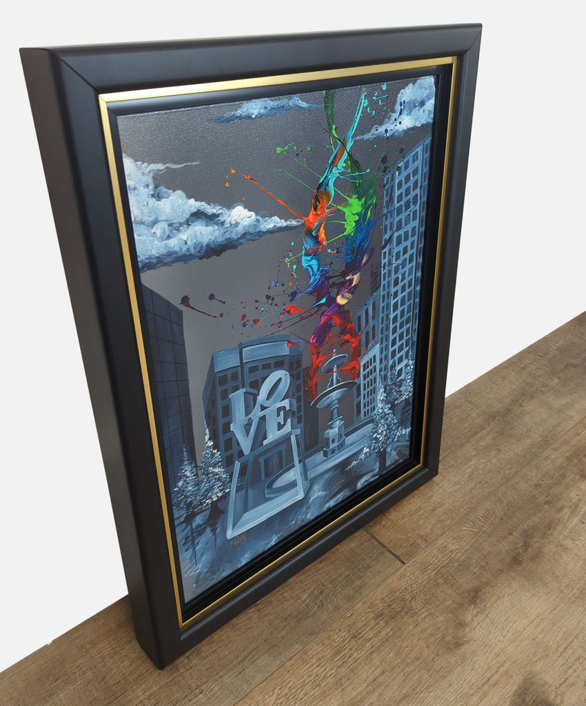 3. Angled view of a signed Kre8 canvas print in a black and gold frame, with bold splashes of color.