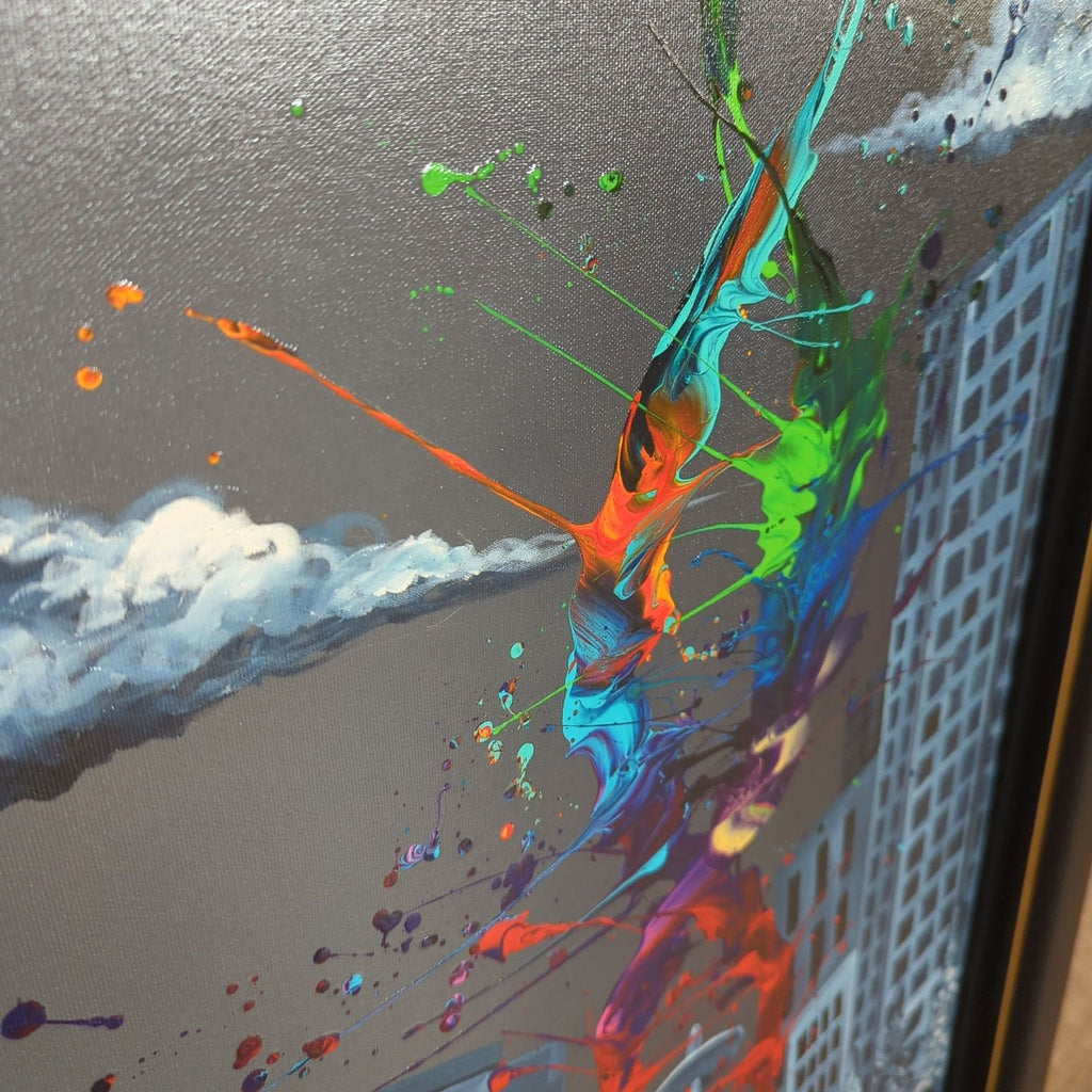 2. Close-up of a Kre8 print, featuring vibrant hand-painted color streaks over a grayscale urban scene.
