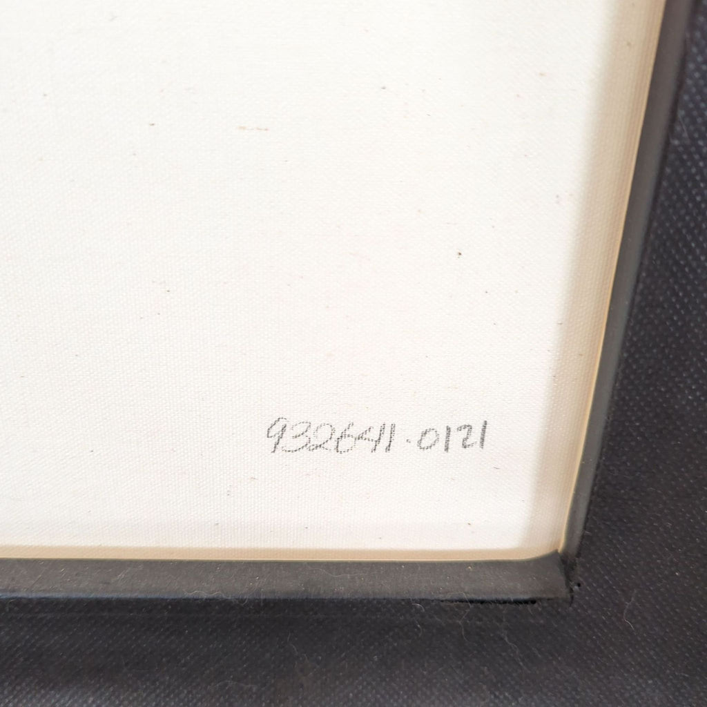 2. Close-up of the framed print's back corner showing a handwritten edition number on the canvas.