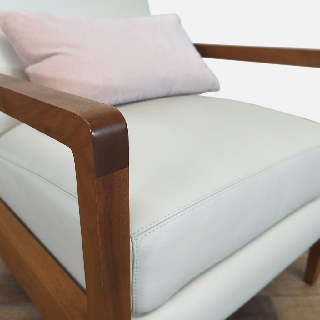 Close-up of the Reperch lounge chair armrest, showing leather upholstery and pink accent pillow.