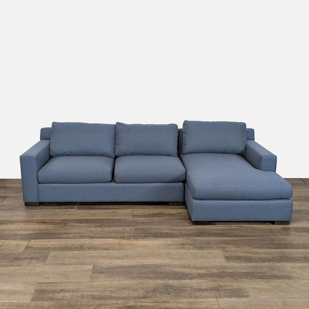 1. Blue McCreary Modern sectional sofa with track arms and loose back cushions on a wooden floor.  