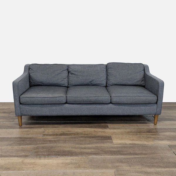 1. Front view of a West Elm 3-seat couch with grey tweed upholstery and wooden legs on hardwood floor.