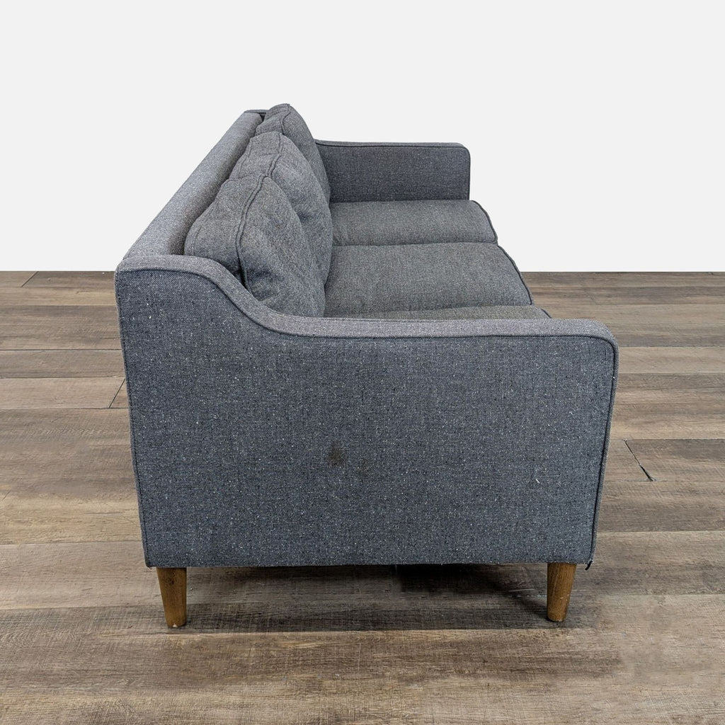 2. Side view of a West Elm grey tweed three-seat sofa, showing slim arms and wooden peg legs.